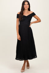 woman wearing a black off-the-shoulder pleated midi dress with a fitted bodice and flared skirt