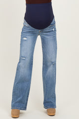 woman wearing distressed light blue maternity jeans with a navy blue over-the-bump panel