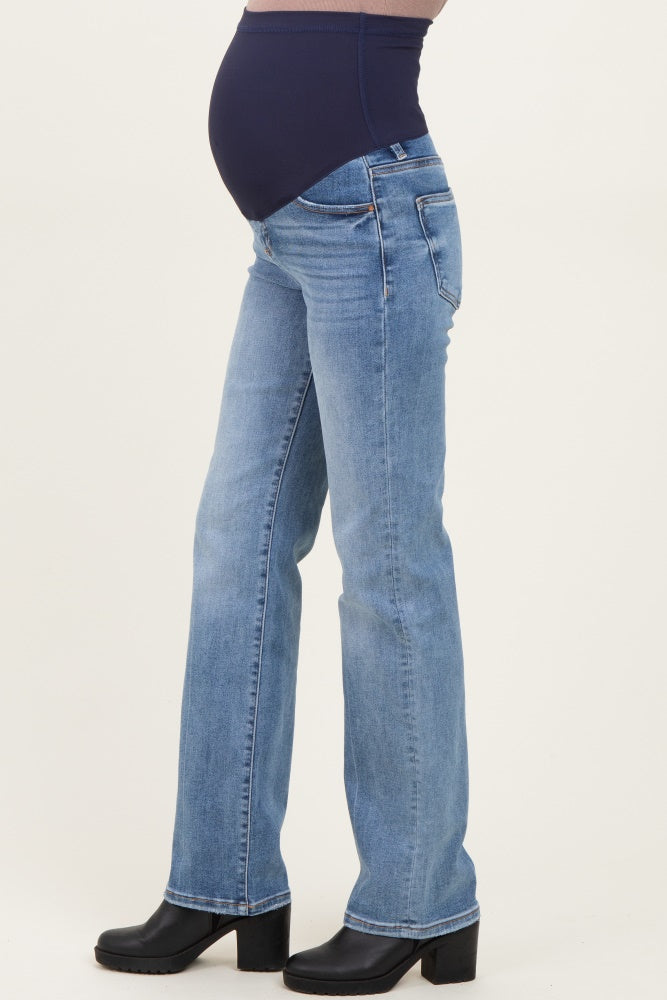 woman wearing light wash maternity jeans with a navy blue over-the-bump waistband and a visible baby bump