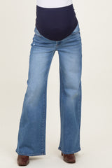 woman wearing light blue maternity flared jeans with a dark blue over-the-bump waistband