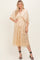 woman wearing a beige midi dress with floral sequin details and short kimono sleeves, styled with strappy black heels