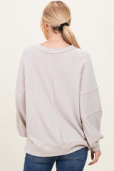 woman wearing a light beige oversized ribbed sweater with a relaxed fit and long sleeves, seen from the back