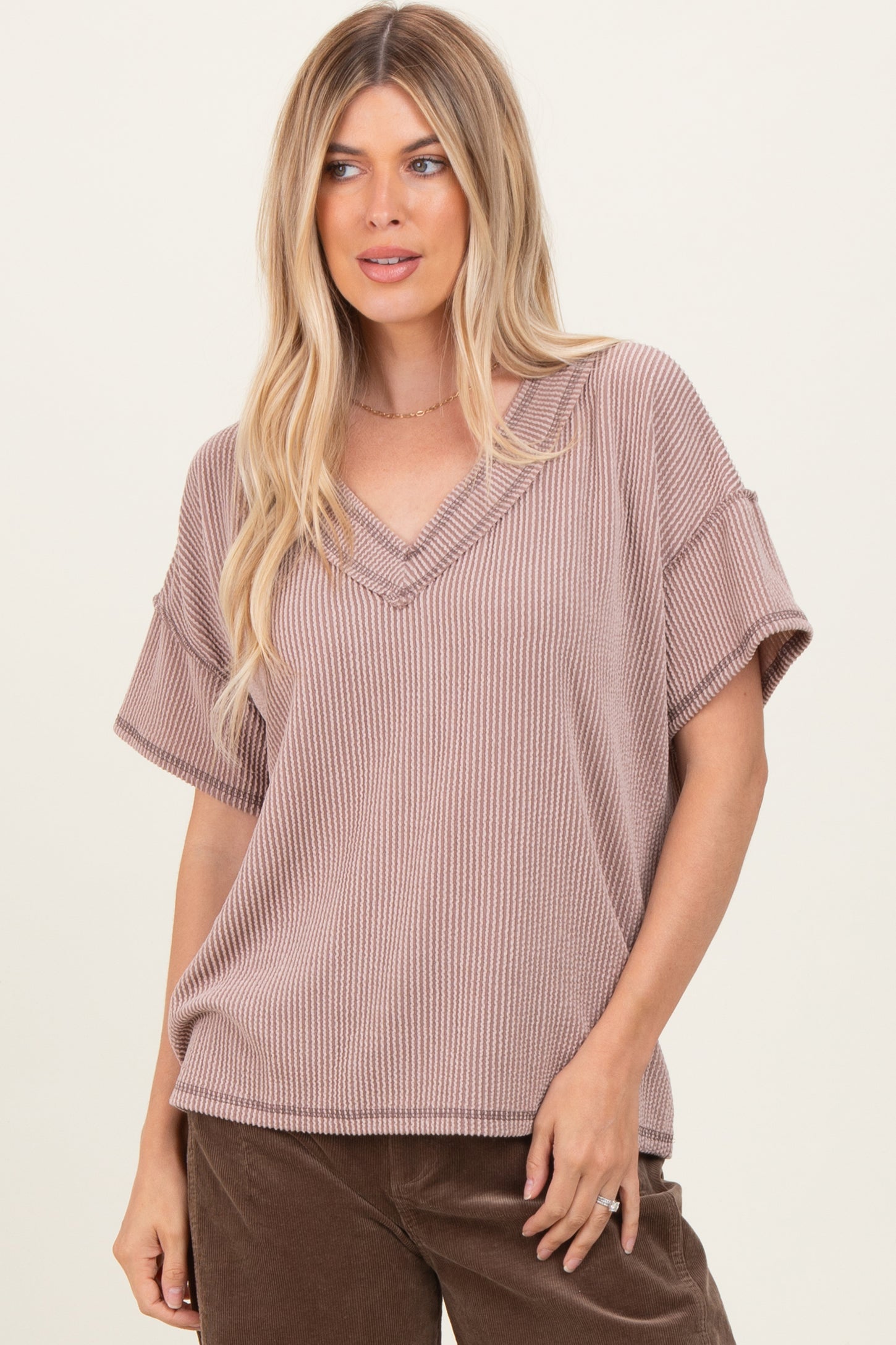 woman wearing a mauve striped short sleeve v-neck top with a relaxed fit