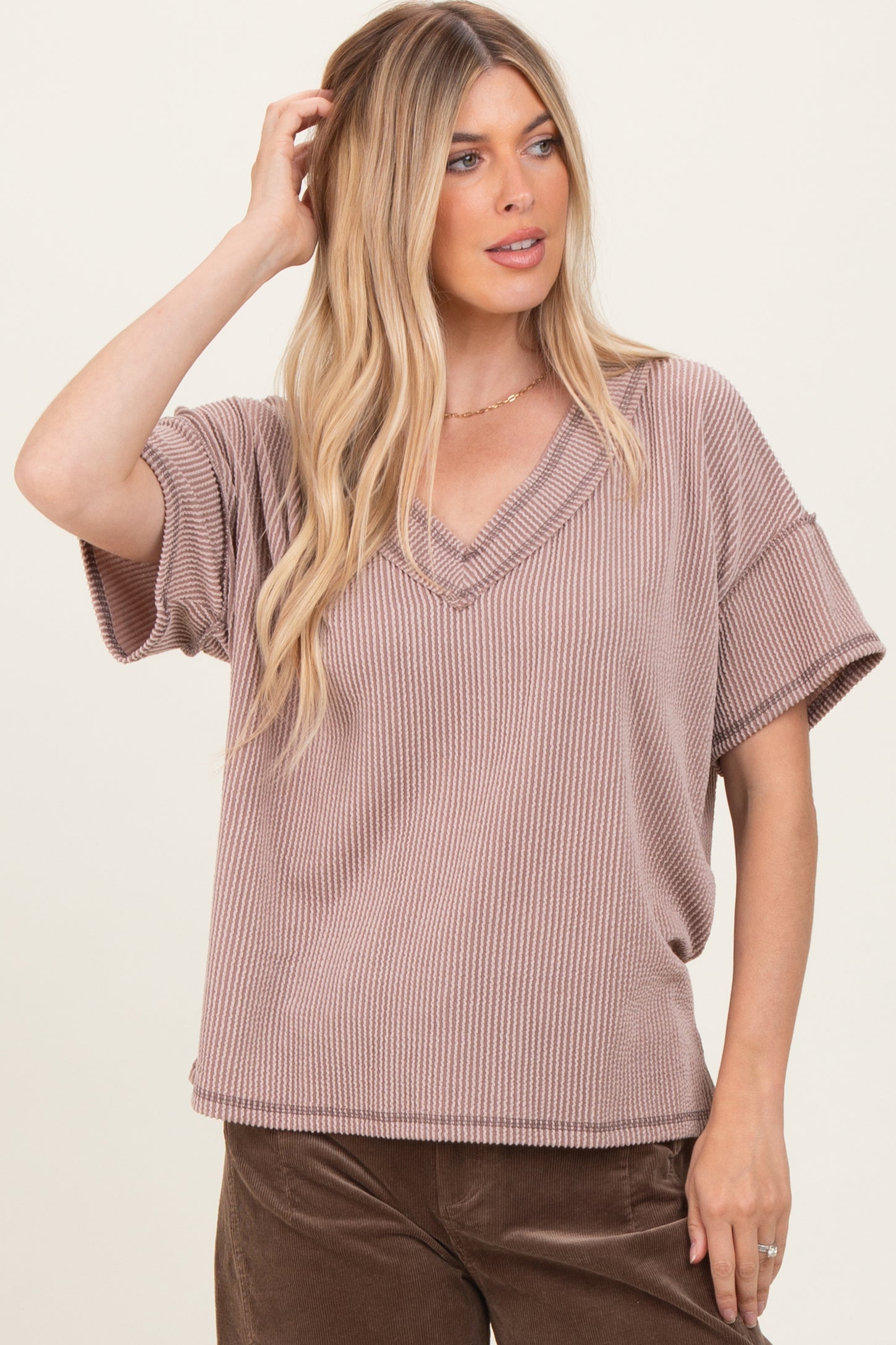 woman wearing a mauve ribbed v-neck short sleeve top with relaxed fit