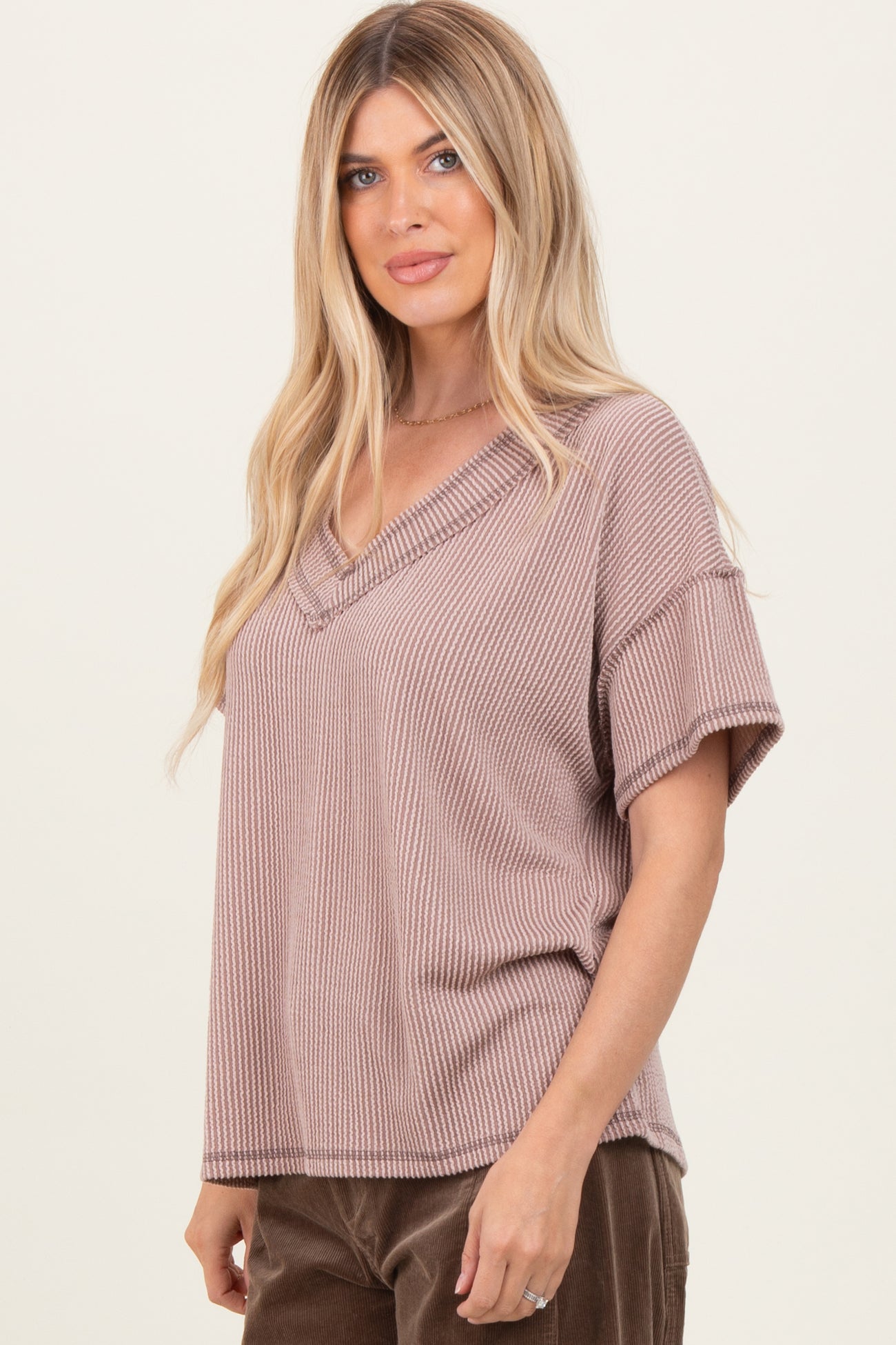 woman wearing a taupe ribbed v-neck short sleeve top
