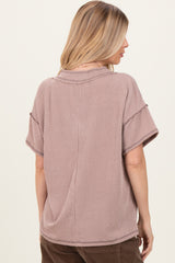 woman wearing a mauve short sleeve oversized ribbed top with a relaxed fit and a round neckline