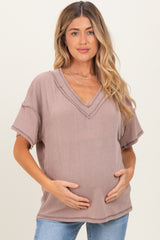 woman wearing a mauve ribbed v-neck maternity top and holding her baby bump