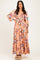 woman wearing a pink floral maxi dress with puff sleeves and tiered hem, standing against a neutral background