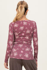 woman wearing a mauve long sleeve maternity top with a floral print, showing a fitted silhouette from the back