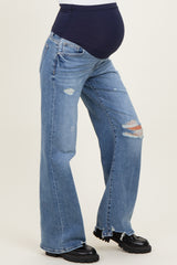 woman wearing distressed blue maternity jeans with a navy belly panel and a visible baby bump