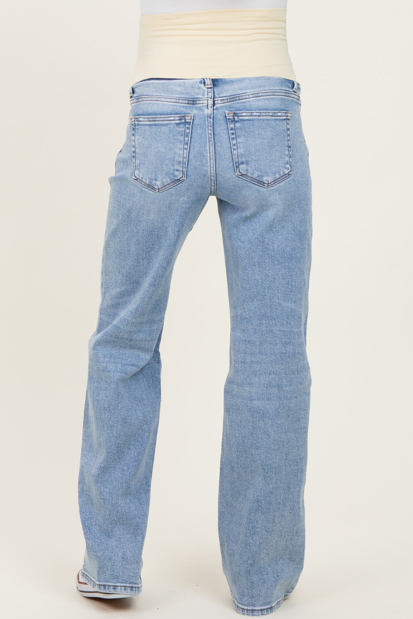 woman wearing light blue maternity jeans with a stretchy waistband, viewed from the back