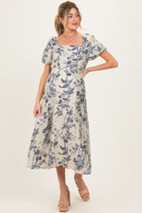 woman wearing a floral print maternity dress with short puff sleeves and a square neckline, visible baby bump