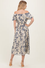 woman wearing a floral off-the-shoulder midi dress with a cinched waist and ruffled sleeves, seen from the back