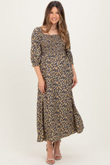 woman wearing a navy floral maternity maxi dress with a square neckline and three-quarter sleeves