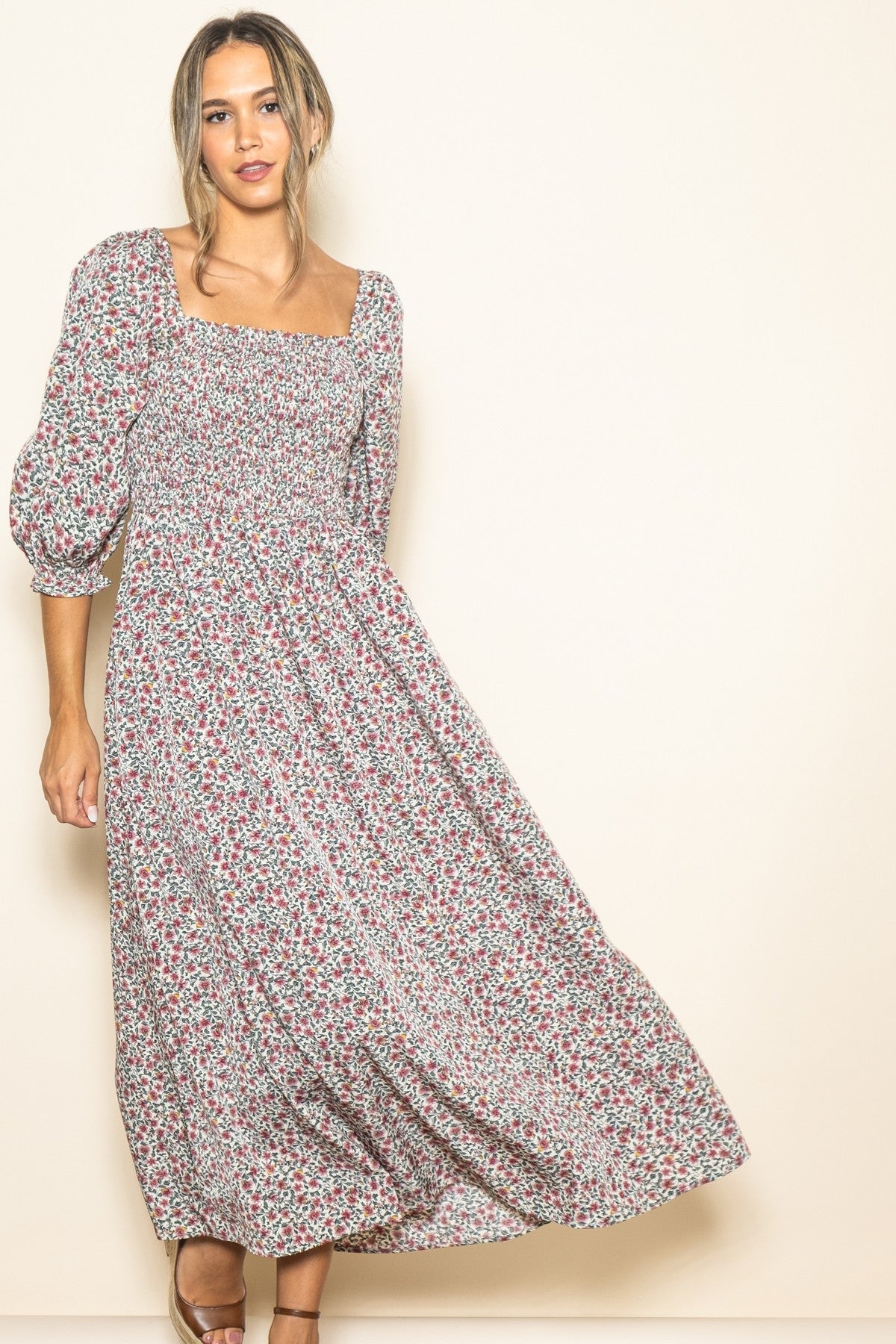 woman wearing a floral long sleeve maxi dress with a square neckline and puffed sleeves