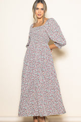 woman wearing a floral print maxi dress with smocked bodice and puff sleeves