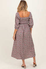 woman wearing a floral maternity dress with puff sleeves and a cinched waist, showing a baby bump from the back