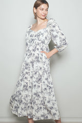 woman wearing a white floral print maxi dress with puff sleeves and side pockets