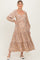 woman wearing a light brown floral maternity dress with long sleeves and a tiered skirt, highlighting her baby bump