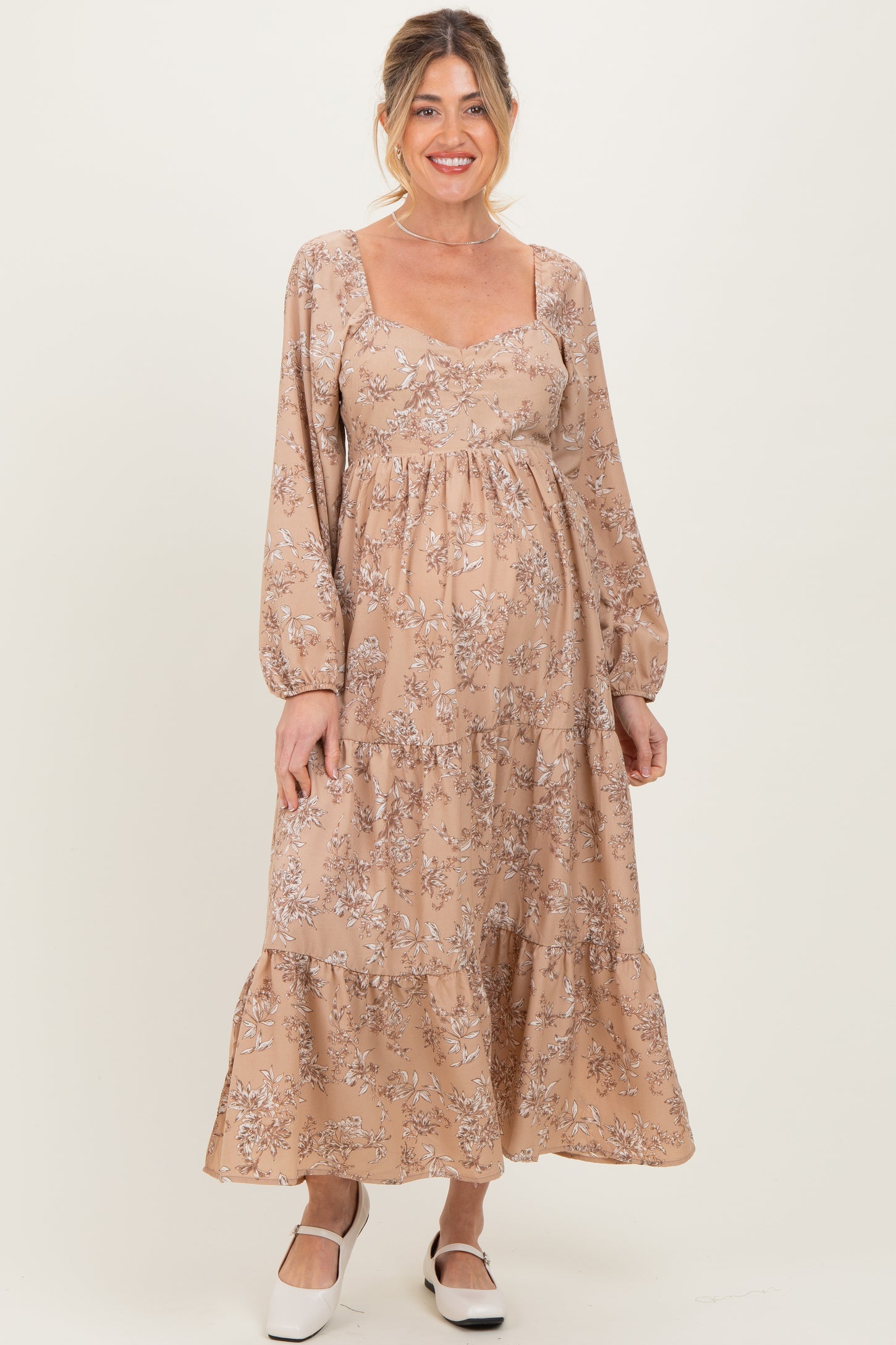 woman wearing a floral print maternity maxi dress with long sleeves and a baby bump visible