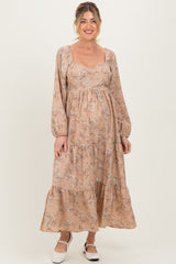 woman wearing a floral print maternity maxi dress with long sleeves and a baby bump visible