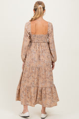 woman wearing a floral maternity maxi dress in beige with a smocked back and long sleeves