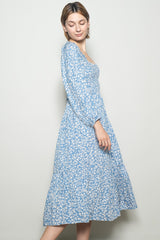 woman wearing a light blue floral midi dress with puff sleeves and a square neckline