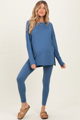 woman wearing a blue maternity activewear set, featuring a long sleeve top and leggings, with a visible baby bump