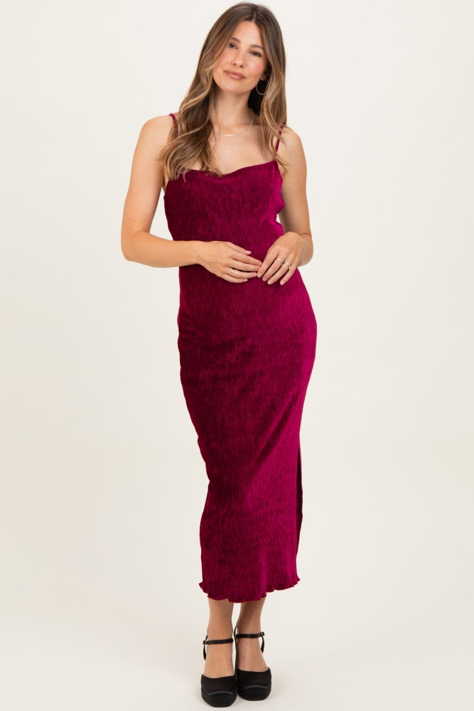 woman wearing a magenta maternity midi dress with slim straps and a side slit, gently holding her baby bump