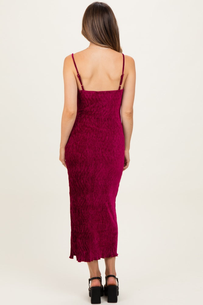 woman wearing a fuchsia spaghetti strap maternity dress with a fitted silhouette and midi length