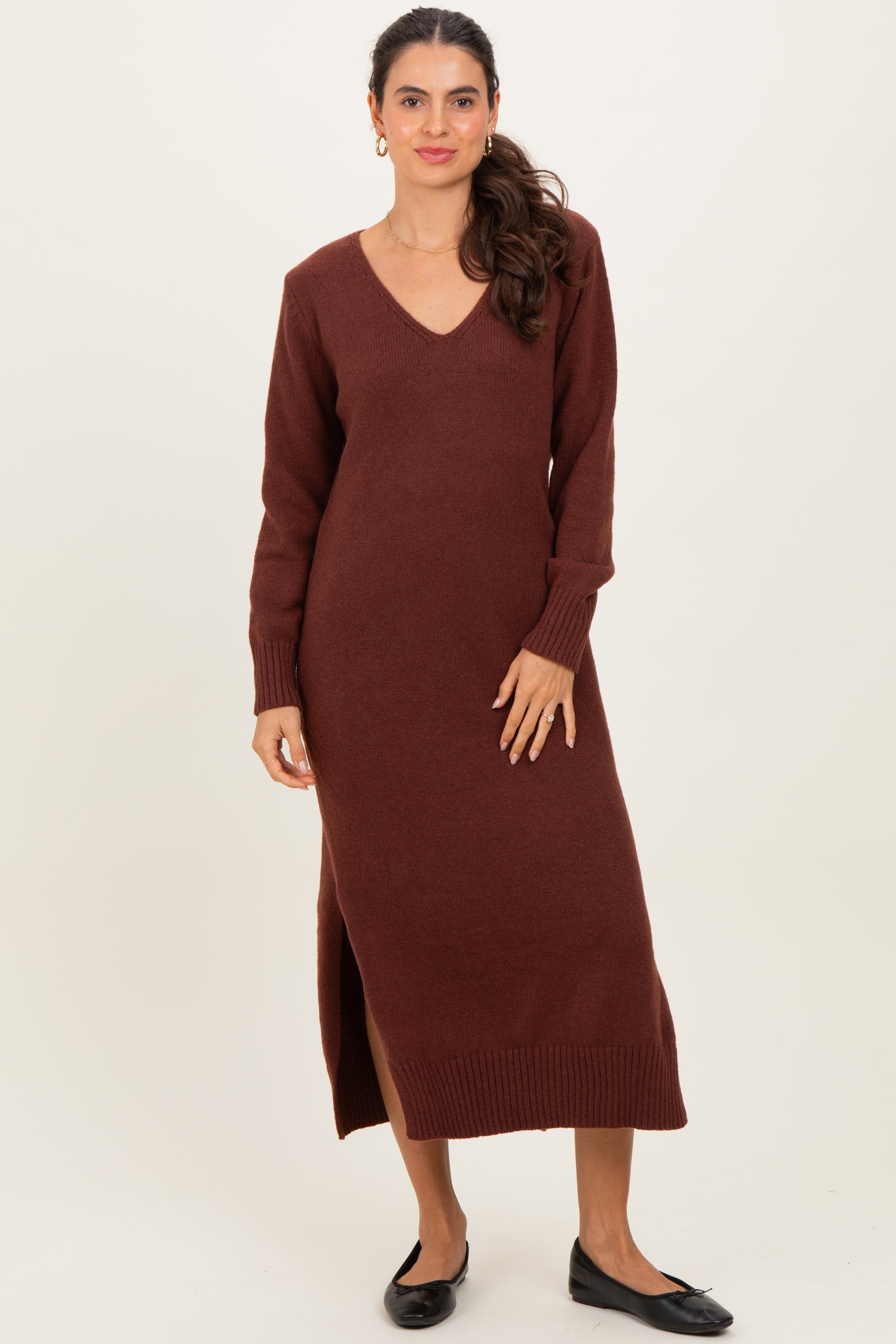 woman wearing a burgundy long sleeve knitted maxi dress with a v-neck and side slit