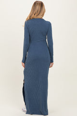 woman wearing a long navy blue ribbed maternity maxi dress with a fitted silhouette and side slits