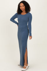 woman wearing a blue ribbed maxi dress with long sleeves and a thigh-high slit, posing against a neutral background