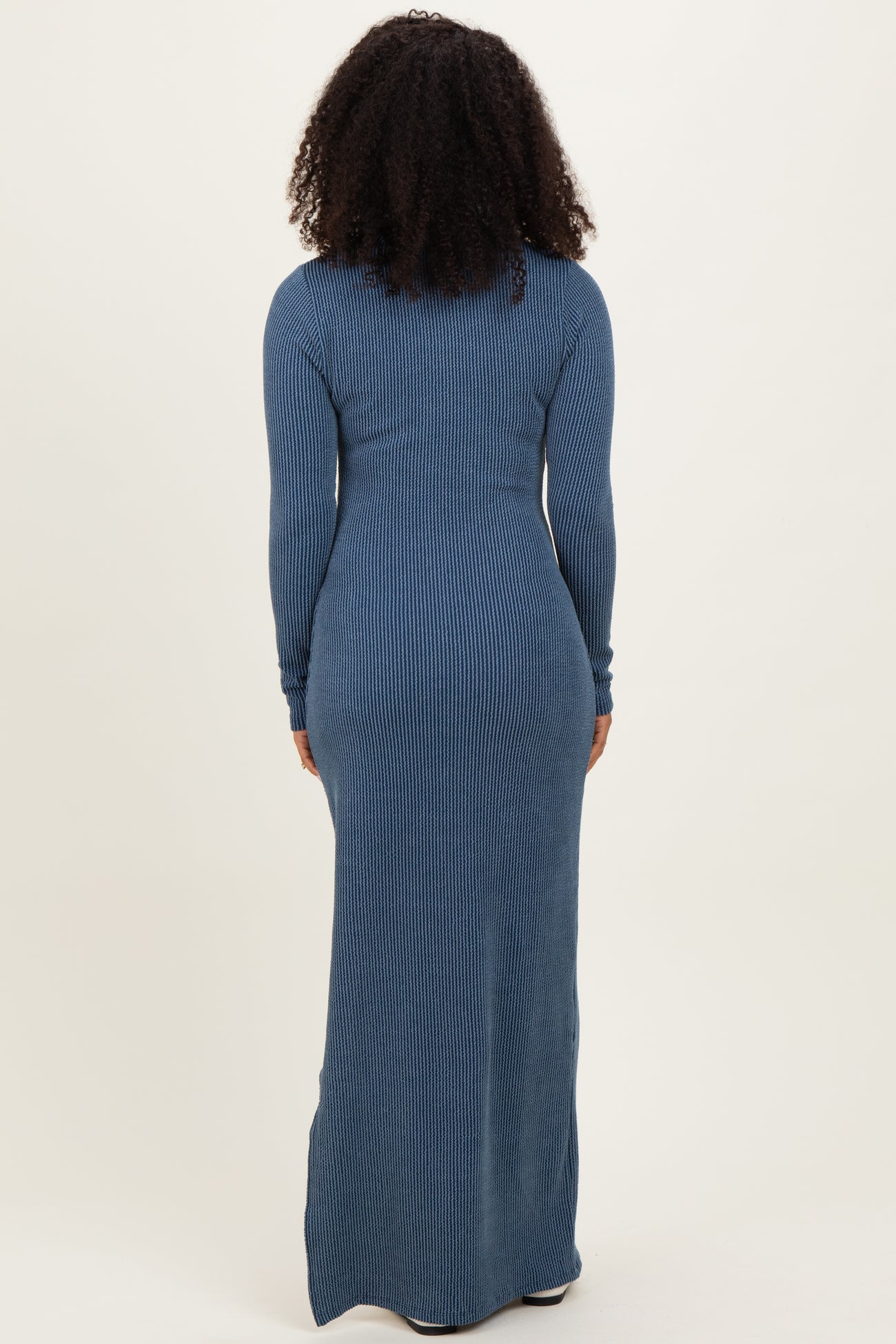 woman wearing a long sleeve ribbed maxi dress in blue, seen from the back
