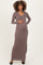 woman wearing a brown ribbed maternity maxi dress and holding her baby bump