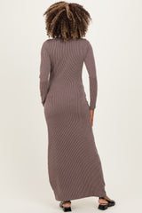 woman wearing a long sleeve brown and cream striped maternity maxi dress, showing the back view