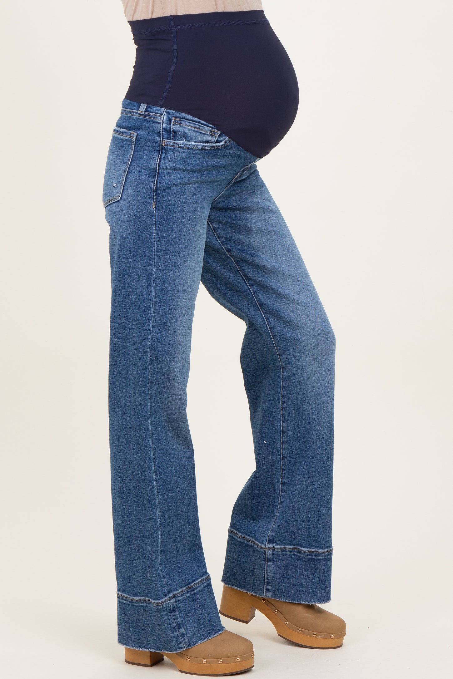 woman wearing blue maternity jeans with a high waistband and visible baby bump