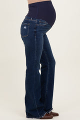 woman wearing dark blue maternity flared jeans with a high waistband and visible baby bump