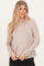 woman wearing a beige long sleeve top with a relaxed fit and round neckline