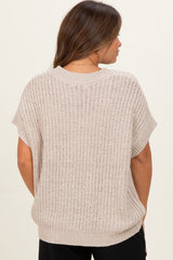 woman wearing a beige loose-knit maternity sweater with short sleeves and a relaxed fit seen from the back