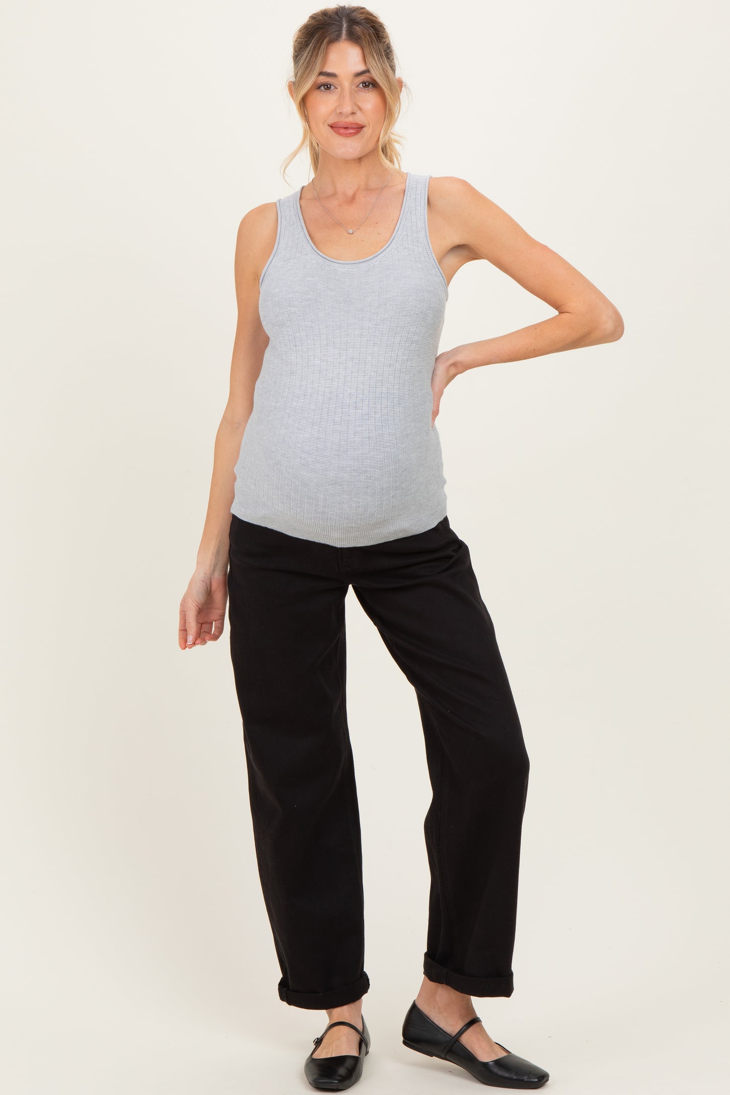 woman wearing a gray ribbed maternity tank top and black pants, showcasing her baby bump