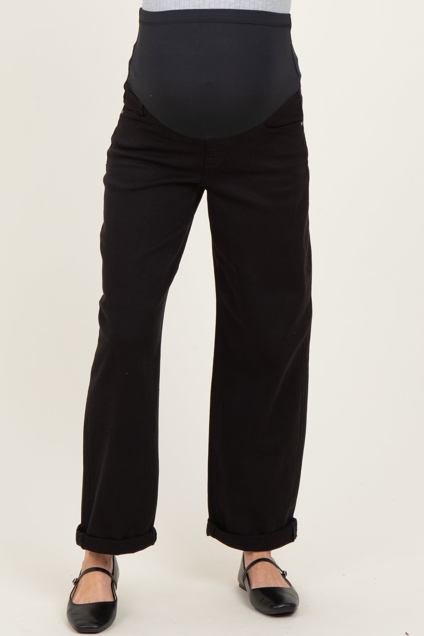 woman wearing black maternity pants with a stretchy belly panel and rolled cuffs