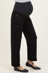 woman wearing black maternity jeans with a high waistband and rolled cuffs, revealing a baby bump