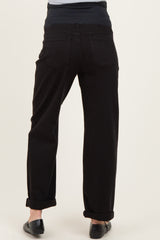 woman wearing black maternity jeans with a rolled hem and a stretchy navy waistband, showing the back view