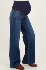 woman wearing dark blue maternity jeans with a supportive belly panel, styled with a wide leg design