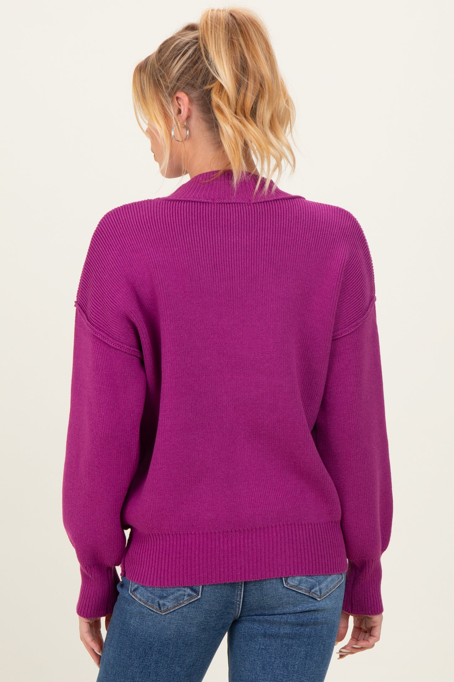 woman wearing a magenta maternity sweater with a relaxed fit and balloon sleeves, showing the back view