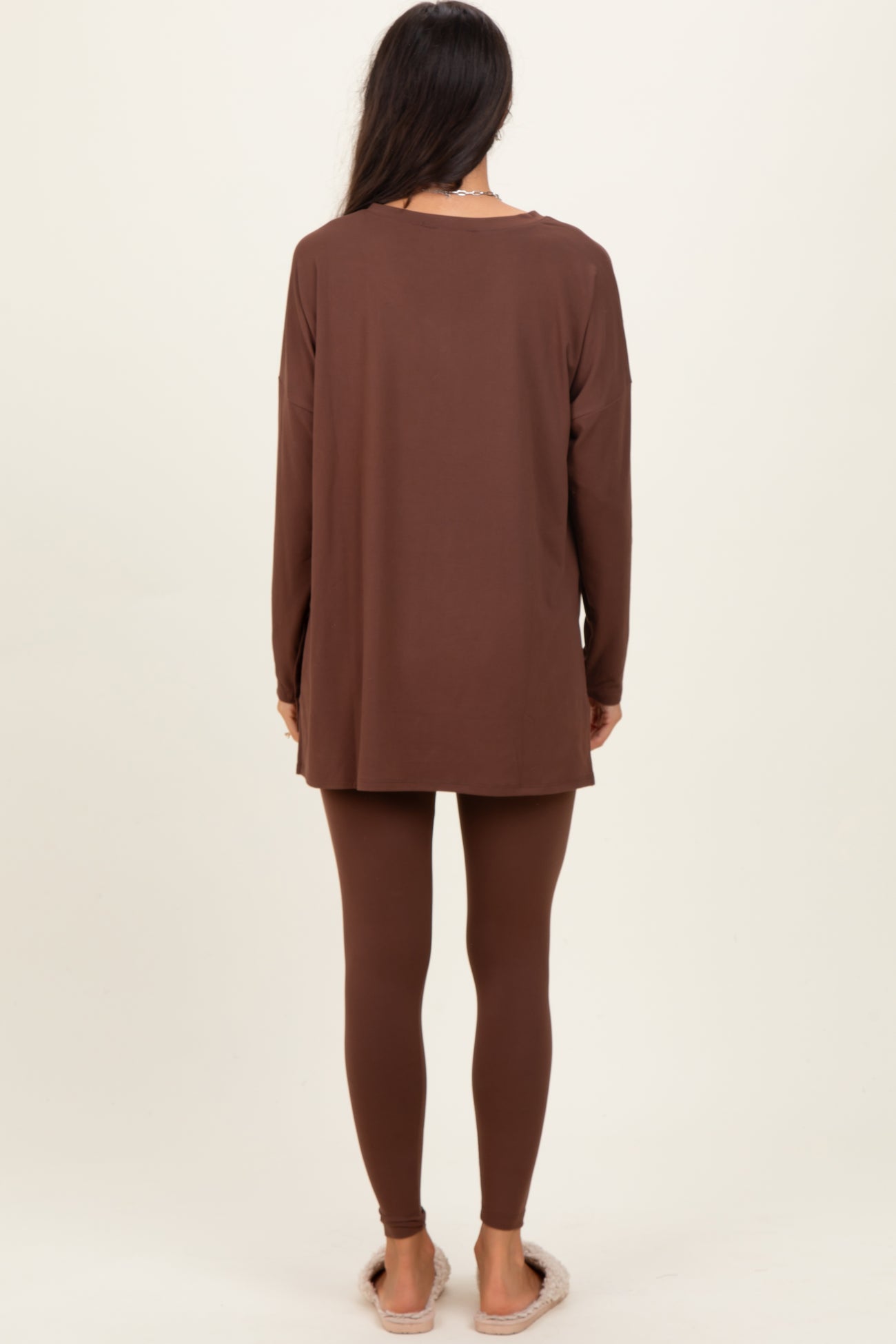 woman wearing a long brown tunic top and matching leggings, viewed from the back