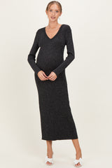 woman wearing a dark shimmer knit maternity dress with a v-neck and long sleeves, showing her baby bump