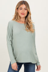 woman wearing a light green long sleeve maternity top with a relaxed fit and flowing silhouette