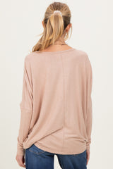 woman wearing a soft pink oversized maternity top, highlighting the relaxed fit and back view